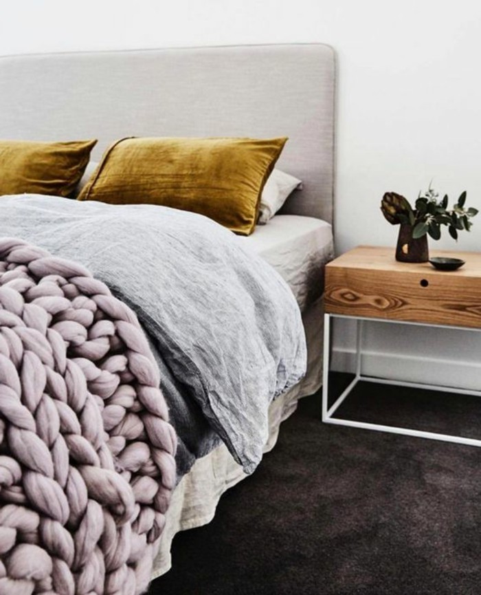 chambre-a-coucher-moderne-couverture-de-lit-tricotee-rose-coussins-jaunes-commode-en-bois