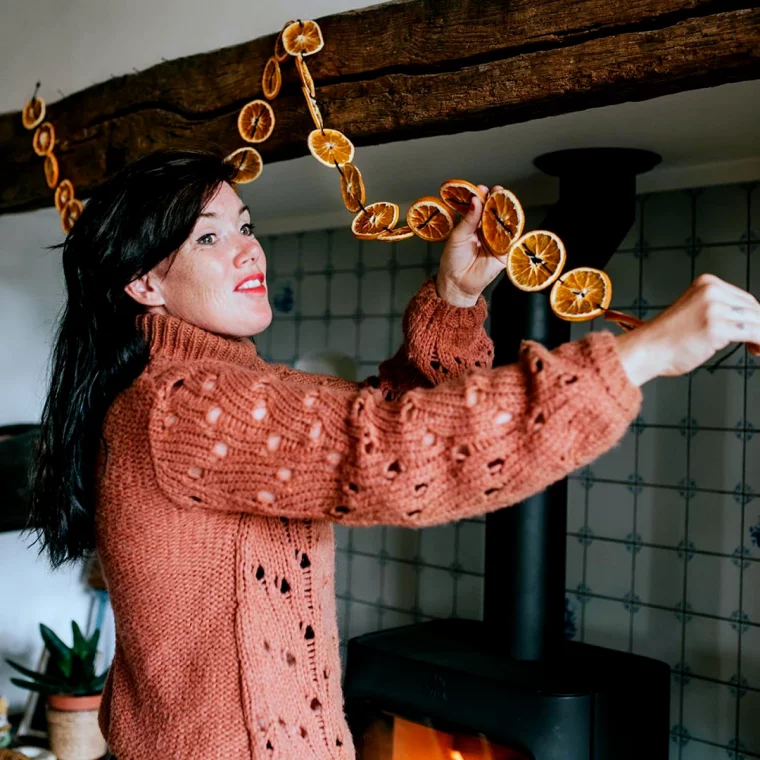 comment faire des guirlandes de noel avec oranges femme souriante