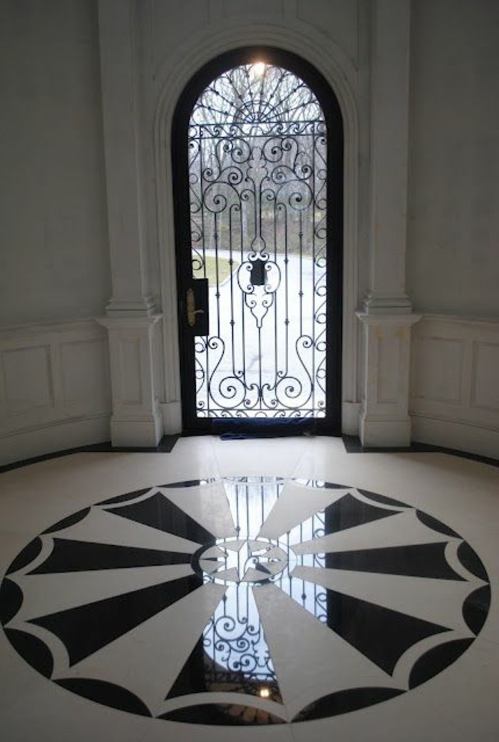 porte-en-fer-forge-couloir-colonnes-en-marbre-cercle-decorative-en-blanc-et-noir