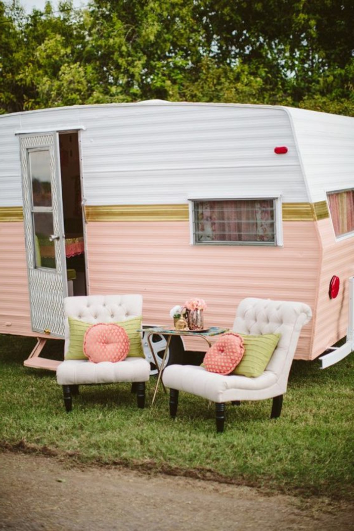camion-caravane-façade-en-blanc-et-rose-couleurs-pastels-fauteuils-pour-un-repos-en-plein-air