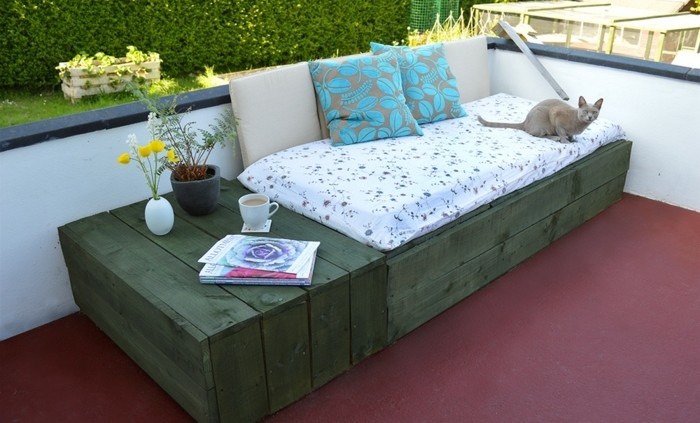 canapé-en-palette-peint-en-vert-sur-une-terrasse-avec-un-espace-de-rangement-petite-table-deco-terrasse-diy