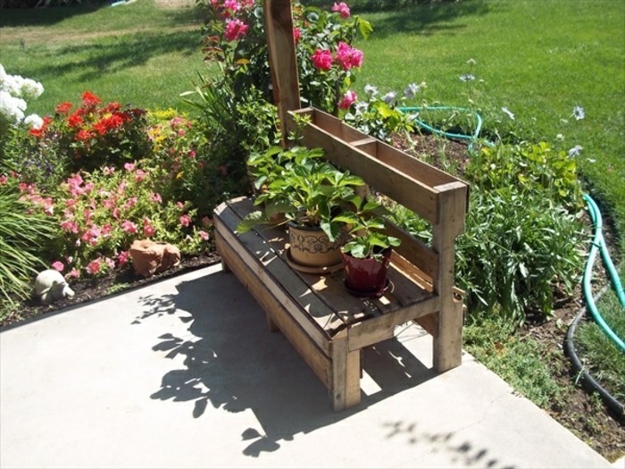 idee-de-banc-palette-dans-un-jardin-fleuri-avec-beaucoup-de-plantes-et-fleur-amenagement-coin-repos-en-plein-air