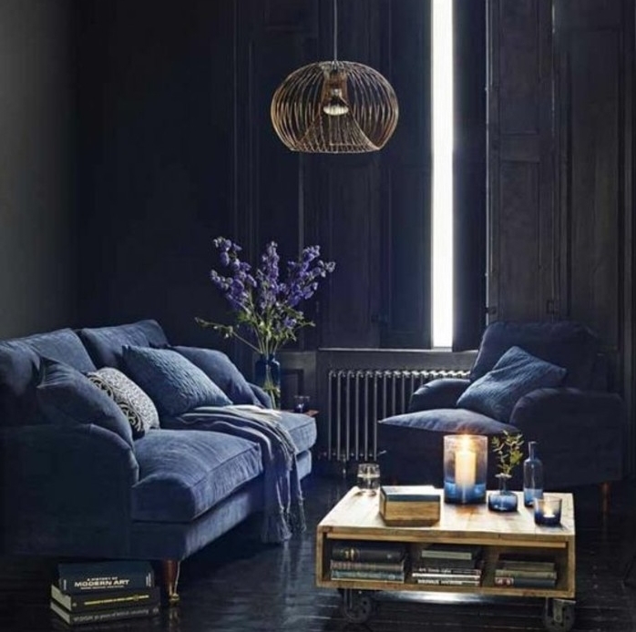 indigo-couleur-murs-et-canapé-et-fauteuil-indigo-table-basse-en-bois-a-roulettes-décor-sombre-dramatique