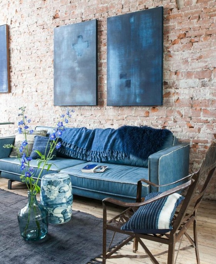 interieur-industriel-elegant-canapé-bleu-paon-accents-bleu-paon-et-bleu-indigo-mur-en-briques-deco-florale