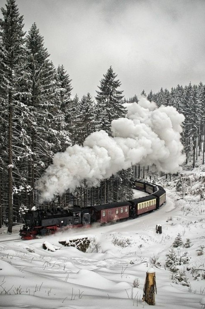 montagne-enneigée-vue-d'en-haut-locomotive-train-rouge-et-noir-sapins