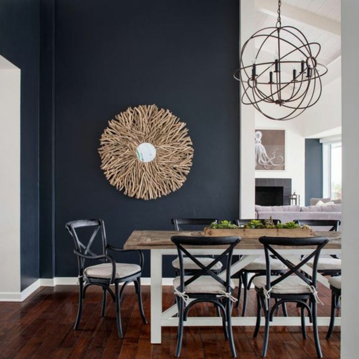 mur-couleur-indigo-dans-une-salle-à-manger-ouverte-parquet-en-bois-chaises-en-metal-table-en-bois-lustre-vintage-en-metal