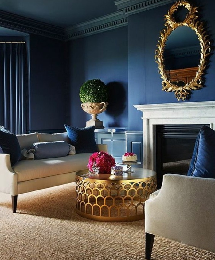 murs-indigo-couleur-cheminée-miroir-encadrement-vintage-canapé-et-fauteuil-blancs-table-basse-dorée-amenagement-salon-bleu