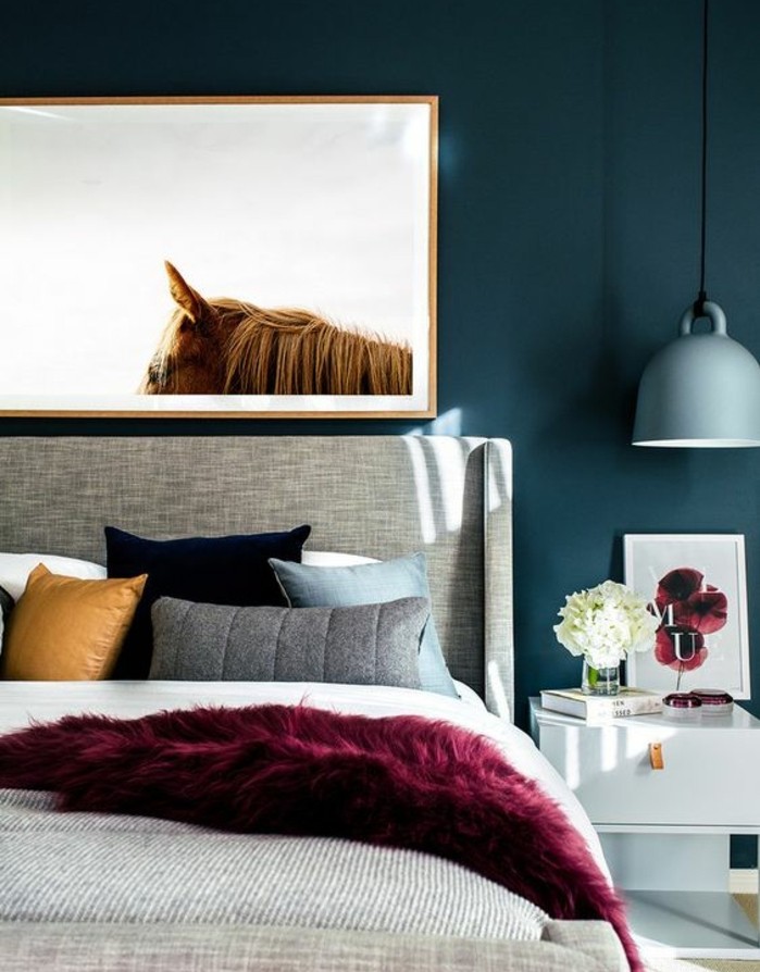 peinture-bleu-paon-pour-la-chambre-a-coucher-deco-murale-tableau-de-cheval-meuble-de-nuit-blanc-avec-des-rangements-lit-gris-coussins-de-couleurs-diverses