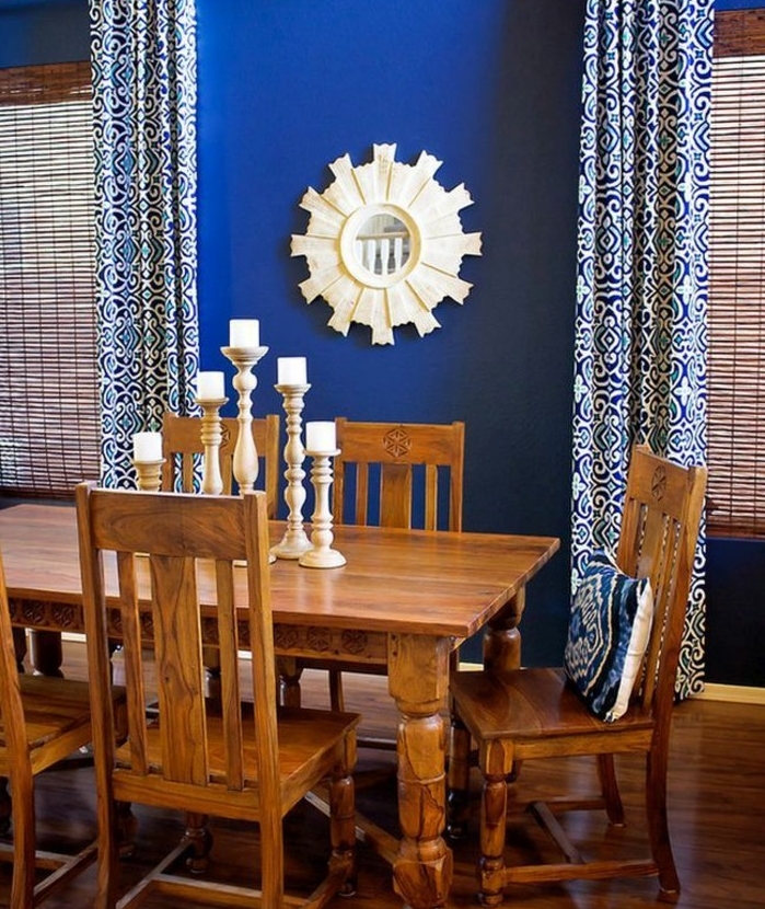 salle-à-manger-chaises-et-table-en-bois-chandelier-miroir-soleil-mur-couleur-indigo-pour-amenager-le-coin-repas