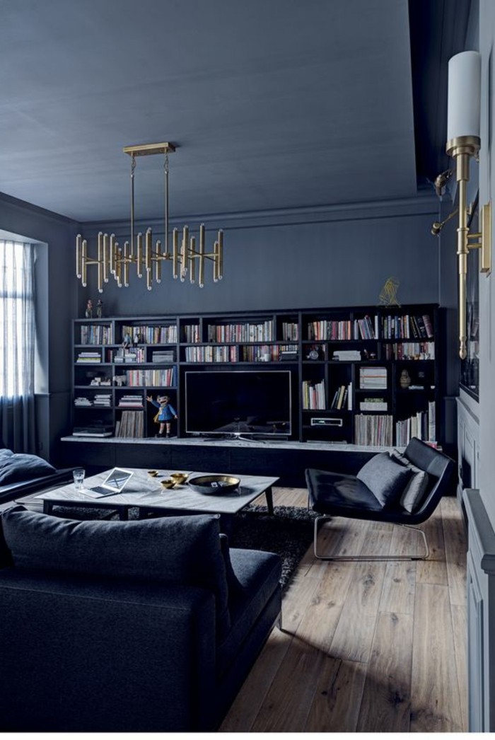 salon-moderne-gris-plancher-de-bois-sofas-noirs-confortables