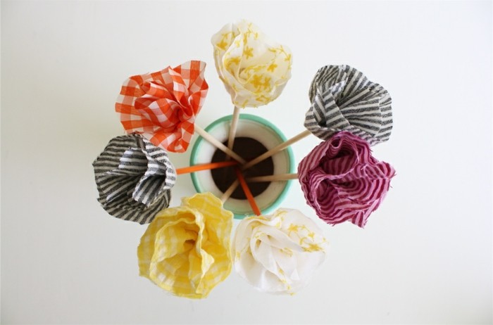 tissu-a-differents-motifs-plié-pour-fabriquer-des-fleurs-idee-comment-faire-des-fleurs-en-tissu-pour-decorer-une-piece
