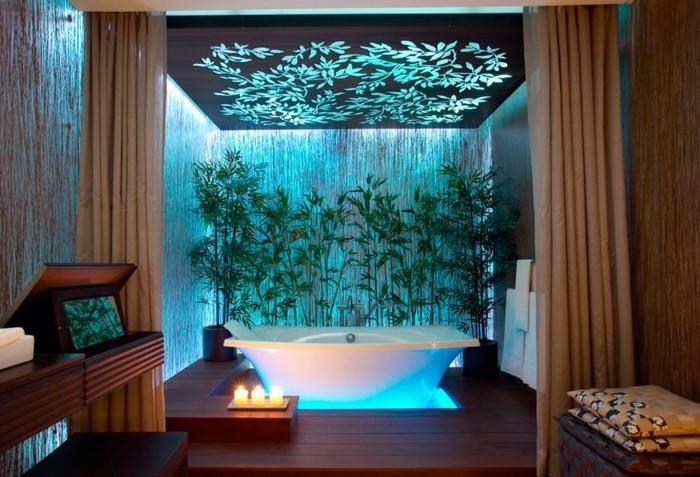 salle-de-bain-turquoise-lumière-mur-végétale-bougies-baignoire-meuble-en-bois