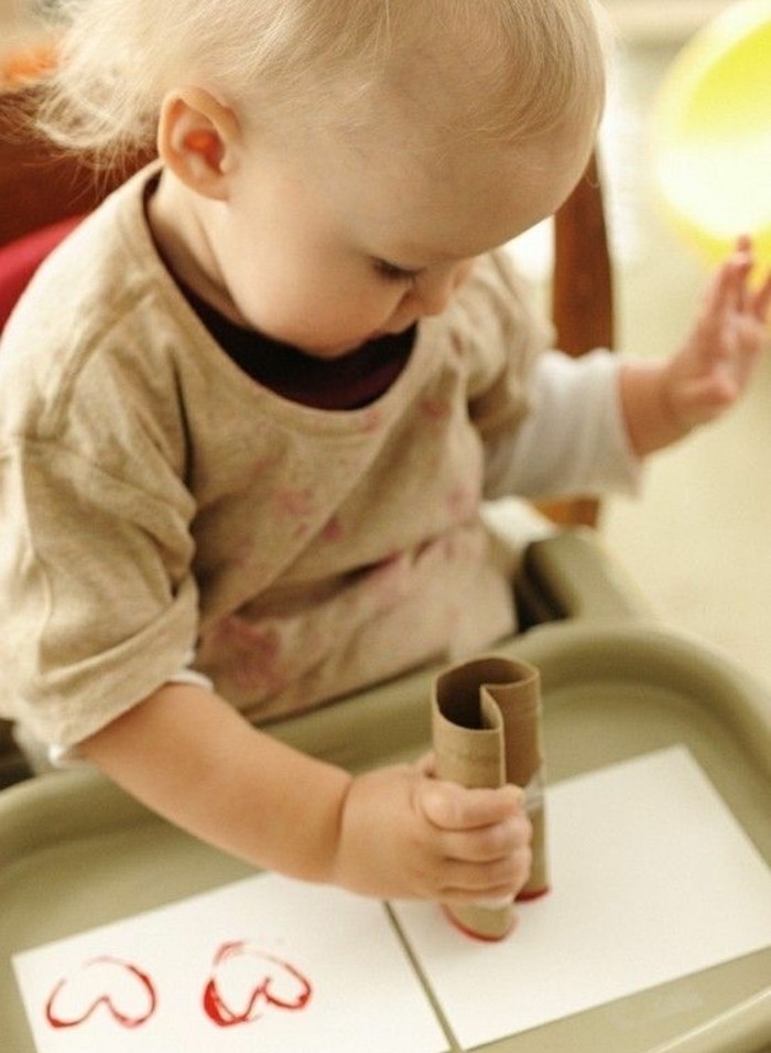 activité créative convenable pour les plus petits, des coeurs empreintes sur du papier à l'aide d'un rouleau de papier toilette