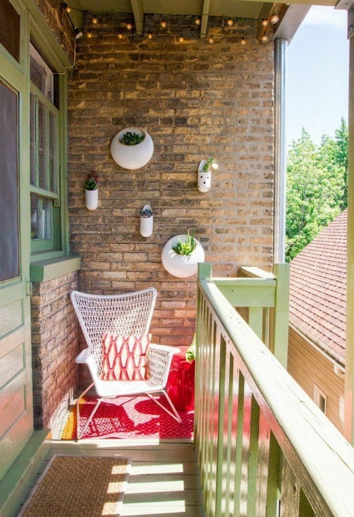 decoration balcon, chaise blanche, tabouret rouge, murs en briques, veranda en vert