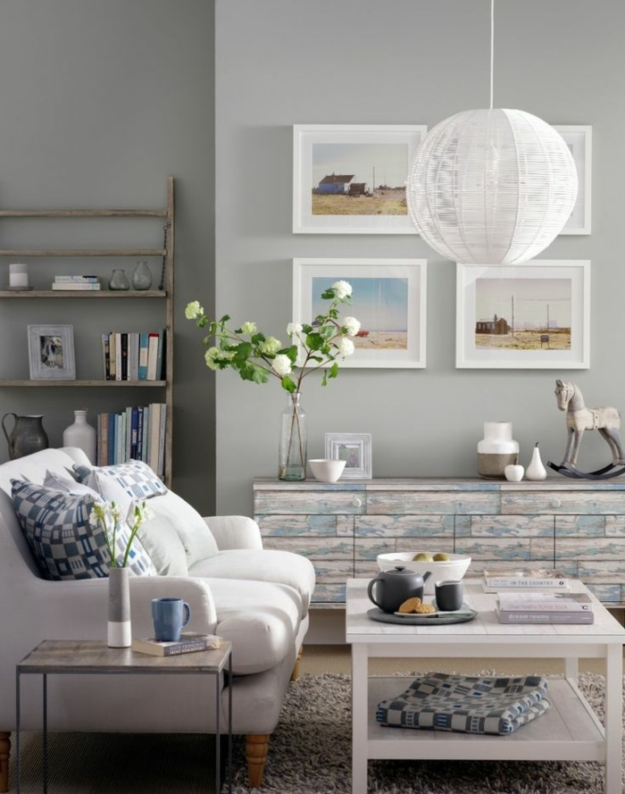 déco salon cocooning, murs gris, canapé blanc, coussins décoratifs, étagères en bois, meuble en palettes