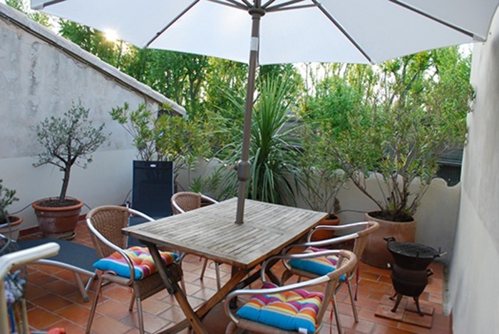terrasse tropézienne, parasol, chaises et table en bois, plantes, carrelage, grès cérame, coussins de chaise arc en ciel, barbecue, 