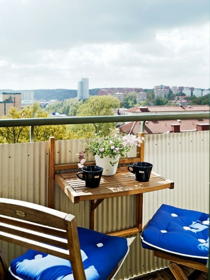 decoration balcon, tasses de café noires, pot à fleurs blanc, housses de coussin bleues