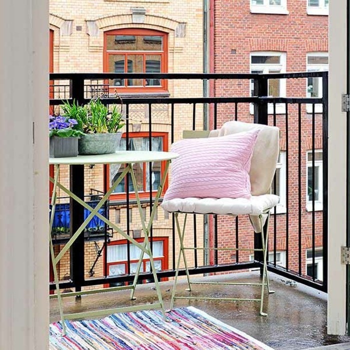 idee deco terrasse, chaise pliante, housse de coussin blanche, coussin rose, tapis multicolore