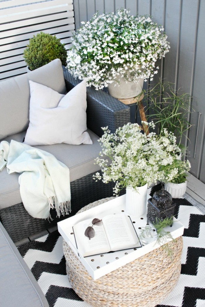 decoration jardiniere exterieure, tapis blanc en motifs triangulaires noirs, couverture blanche à franges