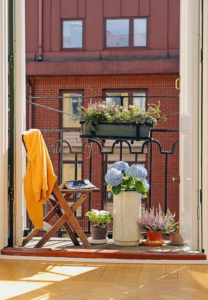 decoration balcon, chaise pliante en bois, rayons du soleil, balcon fleuri
