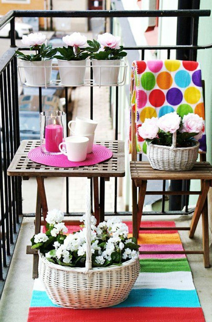 decoration balcon, table en bois, tapis multicolore, bougie rose, tasse de café