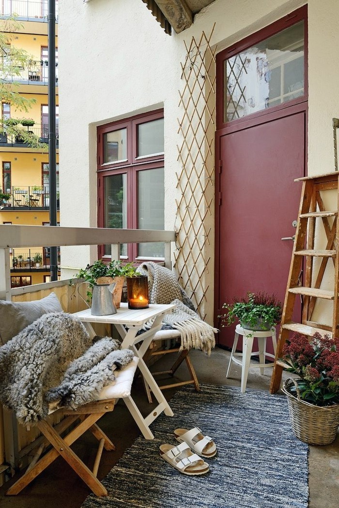 deco balcon, tapis vieux, échelle décorative en bois, pot à fleur en paille, bougie allumée