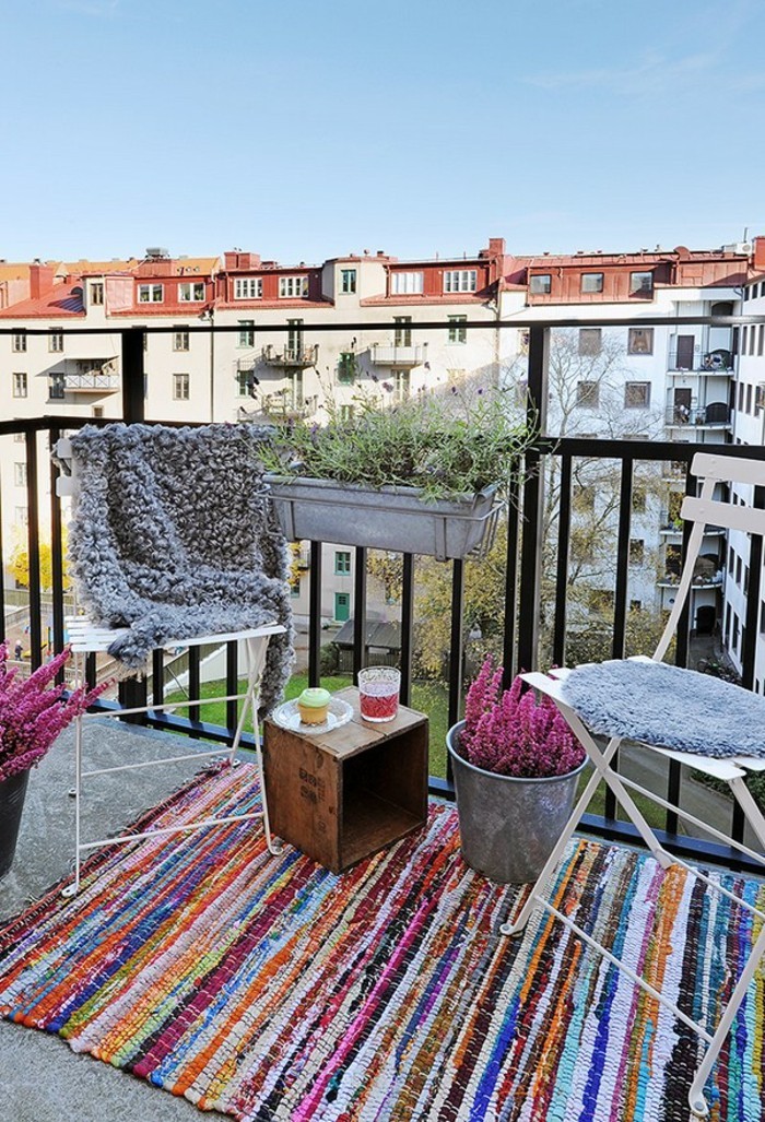 aménager son balcon, tapis multicolore, chaise blanche pliante, couverture en fausse fourrure grise