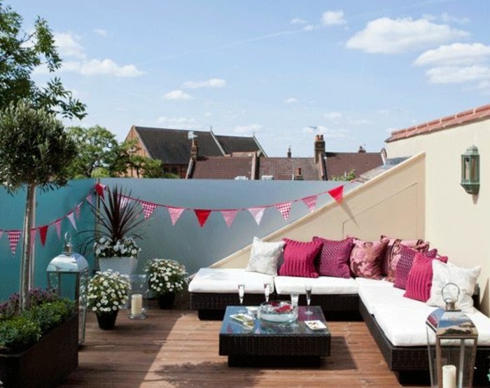 terrasse en composite, canapé d angle, coussins rose, table basse en bois, luminaires, plantes, modèle tropezienne terrasse
