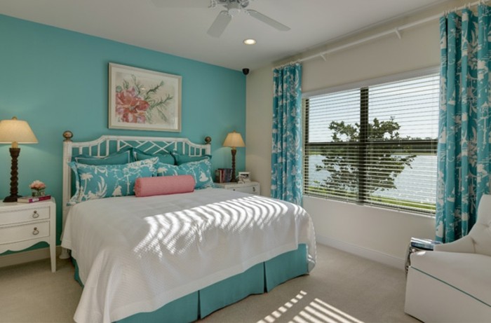 chambre turquoise, grande fenêtre, lampes de chevet, fauteuil et lit blancs