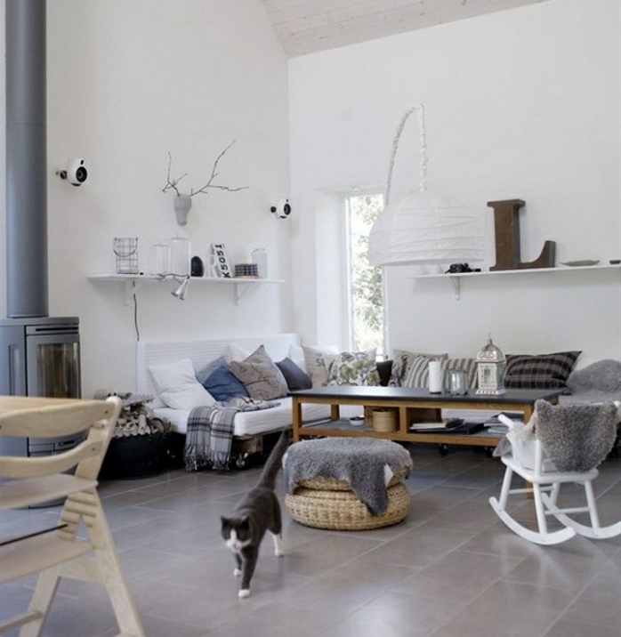 déco cocooning salon, chaise à bascule, canapé blanc, coussins décoratifs, cheminée grise, murs blancs