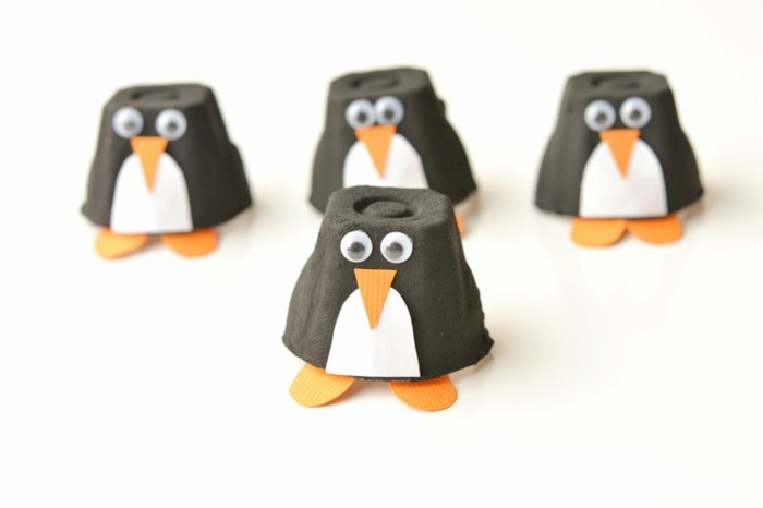 des pingouisne en noir et blanc fabriqués à partir les alvéoles d'une boite à oeufs, nez triangle orange, des pieds