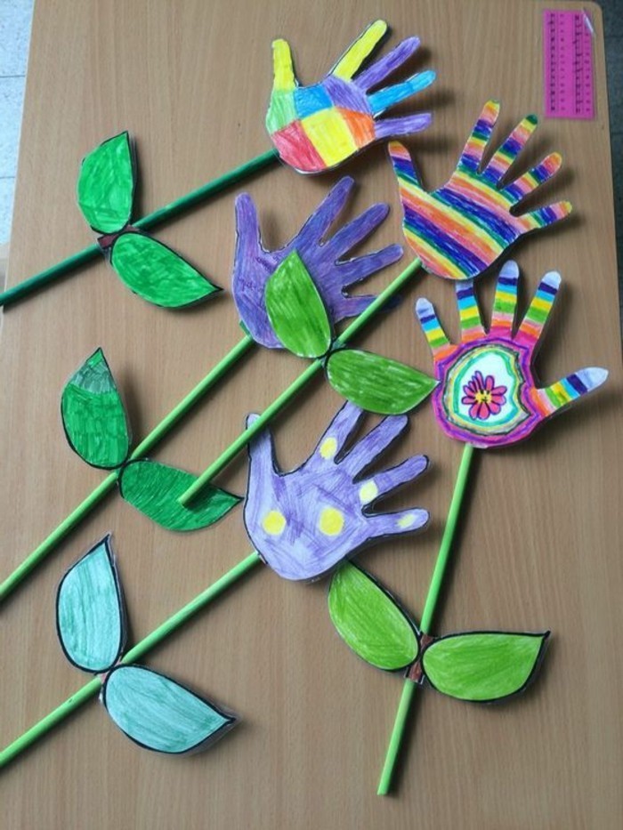 des empreintes de mains en papier transformés en fleurs multicolores, batonnet tige, feuilles en papier, idée activite manuelle maternelle
