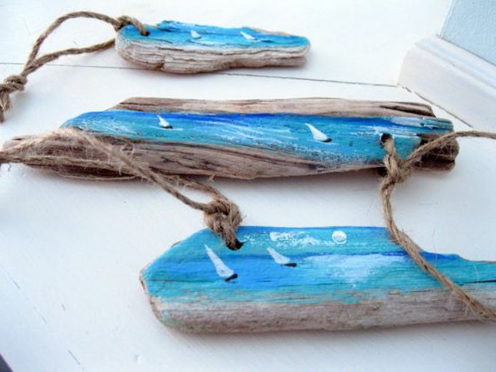 déco bois flotté, petits bateaux dessinés sur des morceaux de bois flotté 
