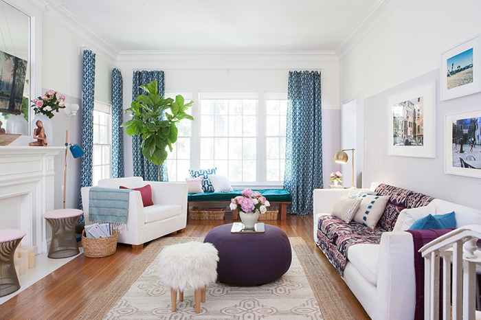 salon cocooning, parquet en bois, rideaux bleus, plantes vertes, fauteuil blanc, pouf, tapis beige