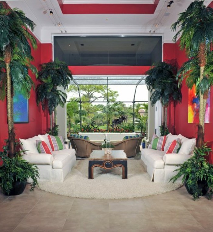 aménager son salon, plafond blanc, murs rouges, plantes tropicales, tapis rond beige