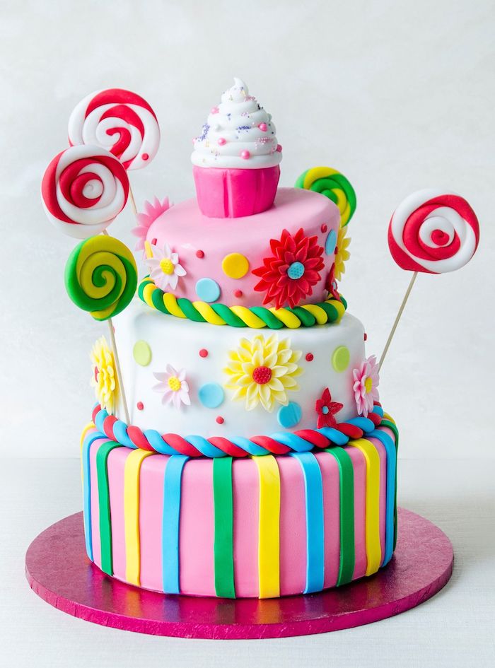  realiser un gateau anniversaire adulte décoré de p6ate à sucre de couleurs variées avec cupcakes en top et sucette de sucre