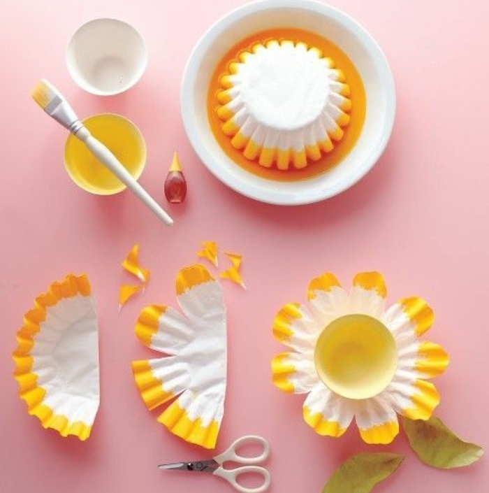 idée-activité-créative-de-printemps-fleur-de-moule-à-muffins-blanche-à-bordure-jaune-avec-un-capuchon-bouteille-au-centre-bricolage-printemps-facile