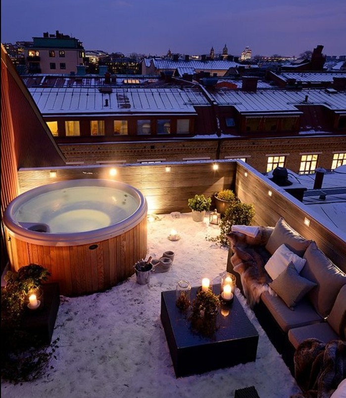 idée comment aménager une terrasse, balnéo, table basse en bois, canapé éclairage romantique, neige, vue urbaine