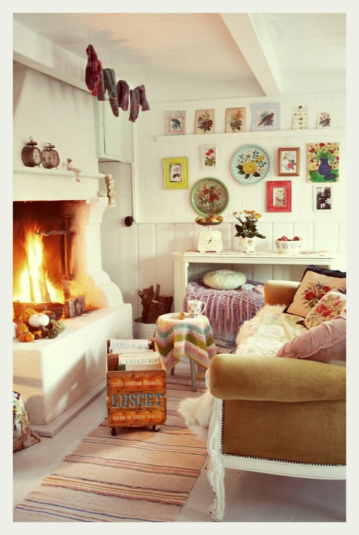 décoration intérieure salon, cheminée allumée, tapis beige, plafond blanc, coussins décoratifs à motifs floraux