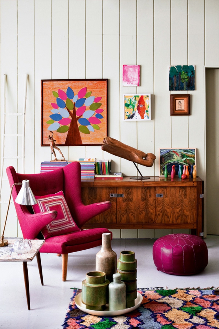 aménager son salon, fauteuil rose foncé, tapis multicolore, murs blancs, armoire en bois