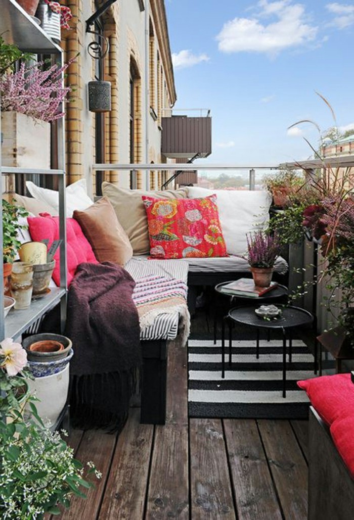 decoration balcon, sol en bois, tapis blanc et noir, étagère à fleurs, coussins décoratifs