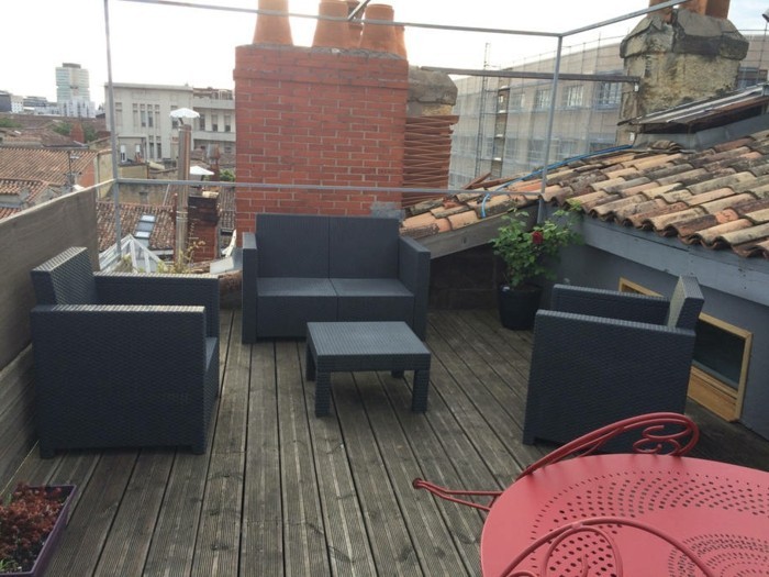 terrasse composite, canapé et fauteuils noirs, table basse noire, idée tropezienne terrasse, plantes, combles