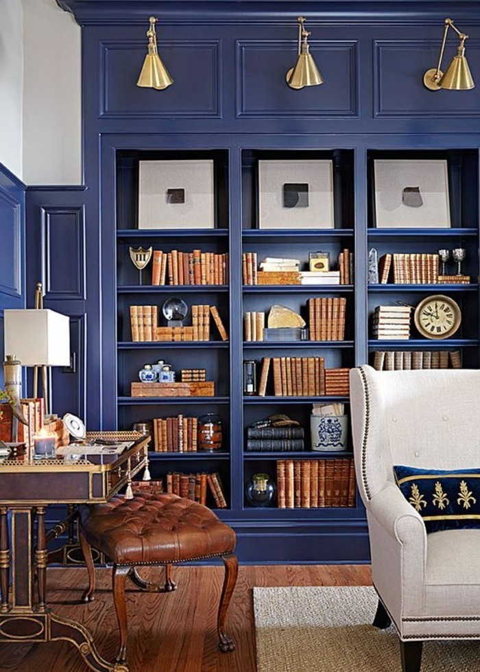 mur de rangement bleu, casiers ouverts, tabouret en cuir capitonné 