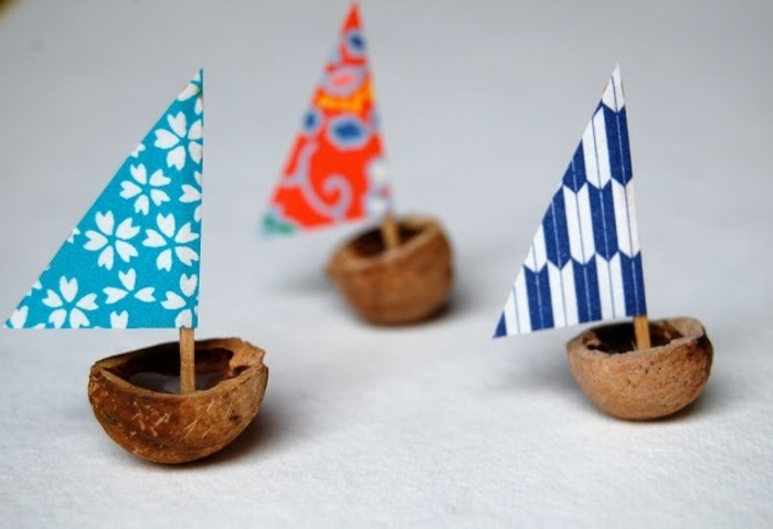 un petit bateau fabriqué à partir de coquille de noix, avec mât en papier et coton tige, idée activité manuelle maternelle, inspiration bord de mer
