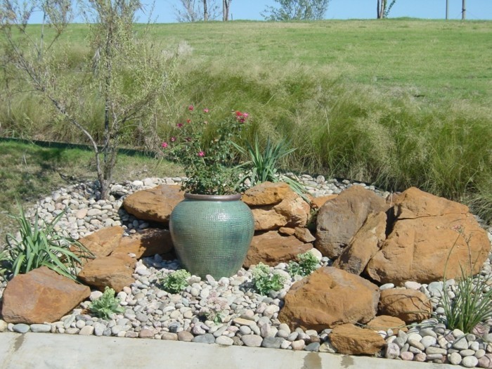 plantes-de-rocaille-vertes-galets-et-grosse-pierre-decoration-jardin-un-grand-vase-en-terre-antique