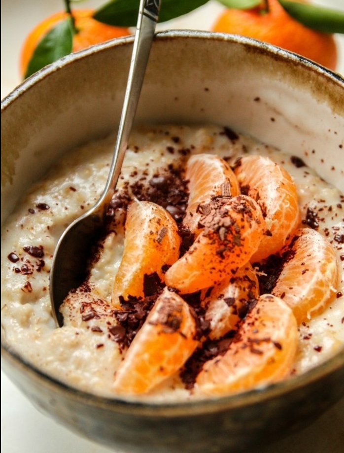porridge recette facile avec des flacons d'avoine, huile d'orange, topping de clémentines, et poudre chocolat chaud