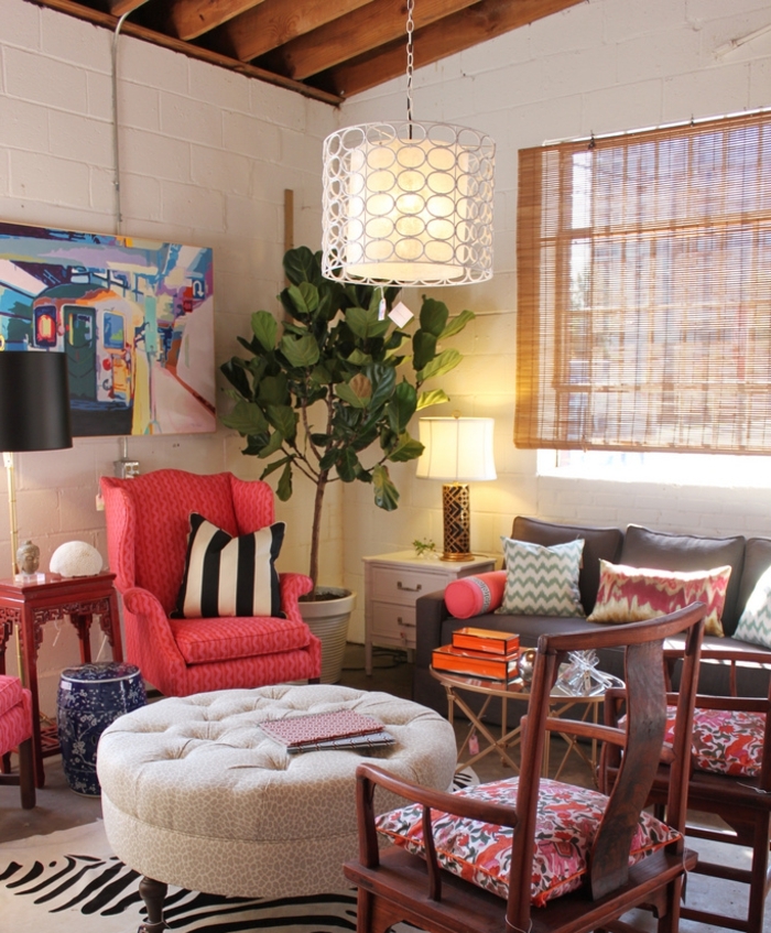 idee deco salon cocooning, fauteuil rose, plafond avec poutres en bois, canapé gris foncé