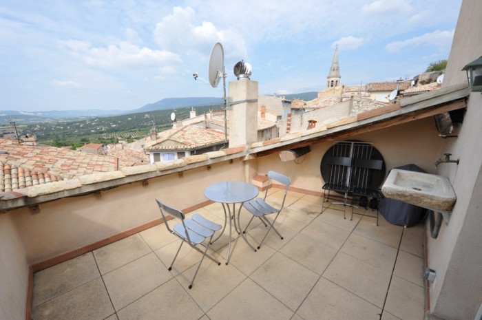 tropezienne terrasse simple, style méditerranéen, chaises et table en métal, robinet en pierre, vue sur la ville