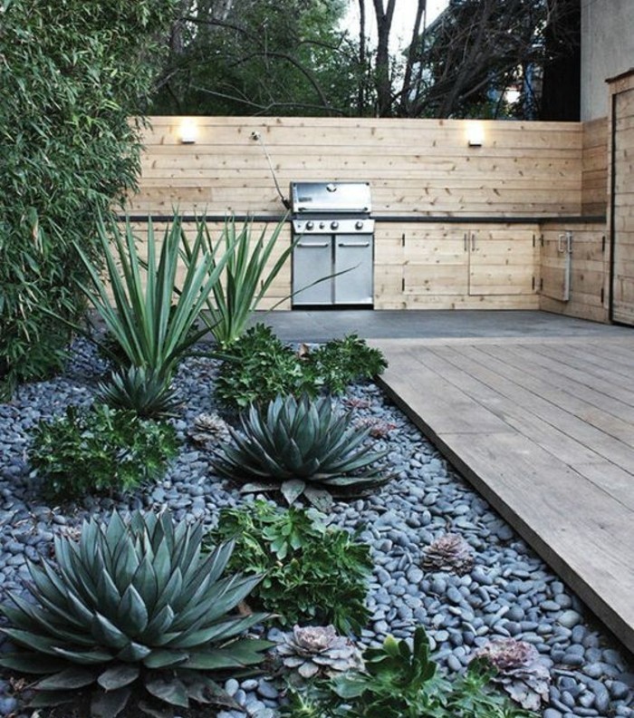 un-jardin-moderne-maison-deck-en-bois-rocaille-jardin-avec-de-succulents-et-galets-gris