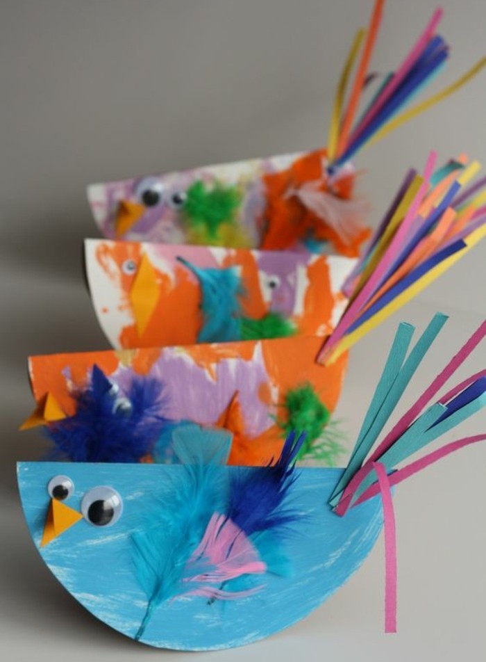 un-oiseau-en-papier-multicolore-decoration-plumes-de-couleurs-diverses-et-bande-de-papier-multicolores-en-guise-de-queue-des-yeux-mobiles-exemple-activité-créative-de-printemps